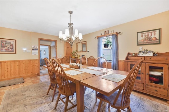 tiled dining room featuring a notable chandelier