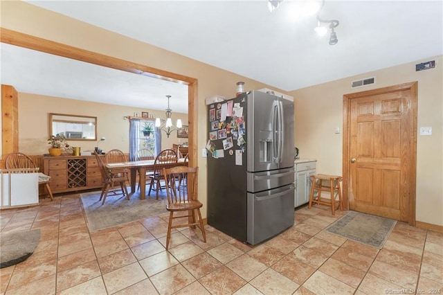 kitchen with light tile floors, a notable chandelier, and stainless steel fridge