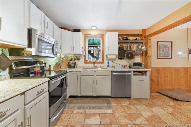 kitchen with tasteful backsplash, white cabinets, light tile floors, stainless steel appliances, and sink