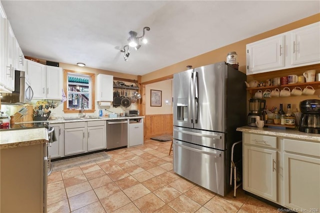 kitchen featuring stainless steel appliances, white cabinets, light tile floors, and sink