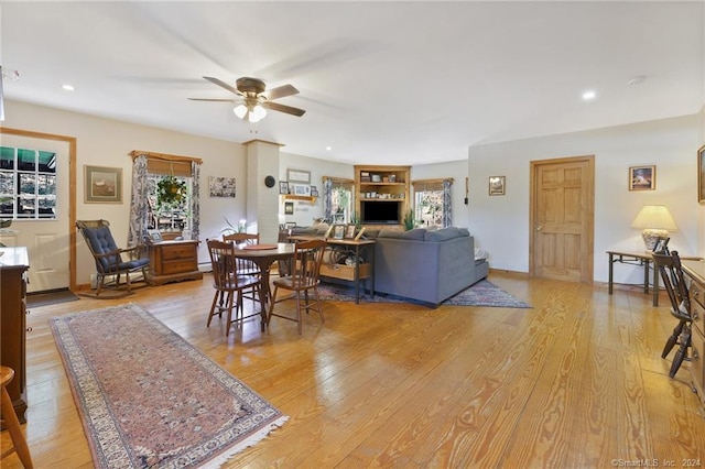 living room featuring ceiling fan and light hardwood / wood-style floors