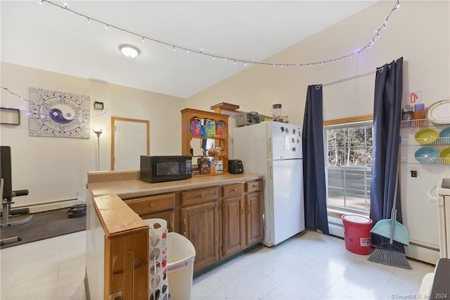 kitchen with baseboard heating, track lighting, white refrigerator, and light tile floors