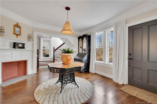 dining room with ornamental molding and hardwood / wood-style flooring