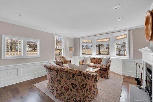 living room featuring crown molding, dark hardwood / wood-style floors, and a wealth of natural light