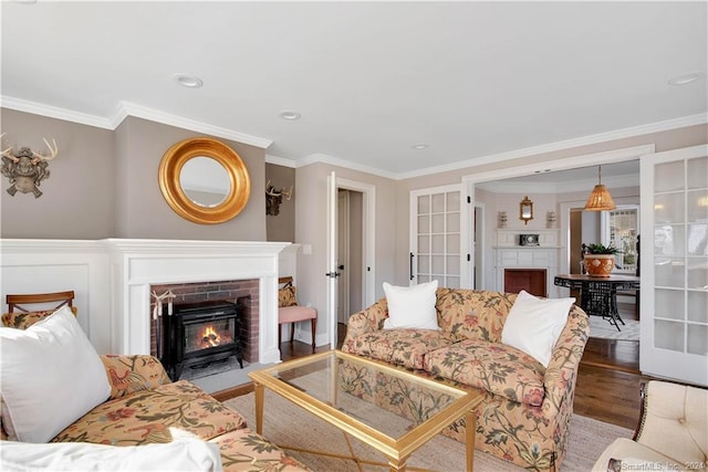 living room featuring ornamental molding, a fireplace, dark hardwood / wood-style floors, and french doors