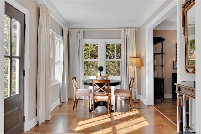 dining area with ornamental molding and light wood-type flooring