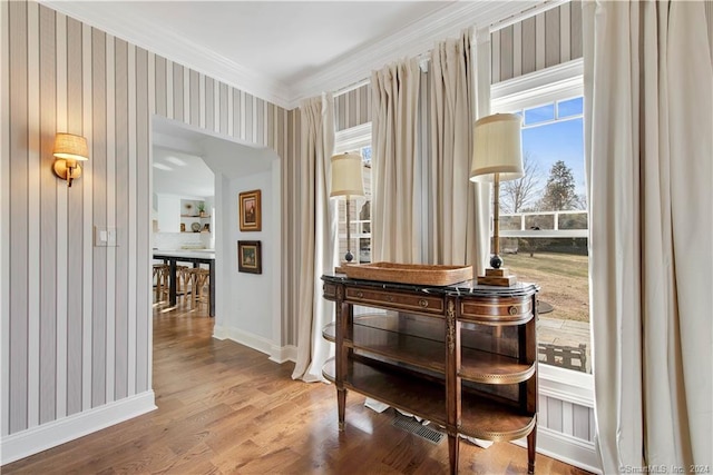 interior space with ornamental molding and wood-type flooring