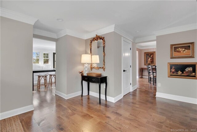 corridor featuring dark wood-type flooring and ornamental molding