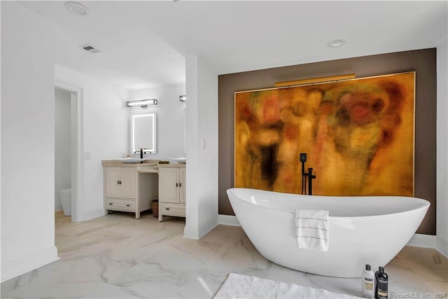 bathroom with a washtub, vanity, and tile flooring