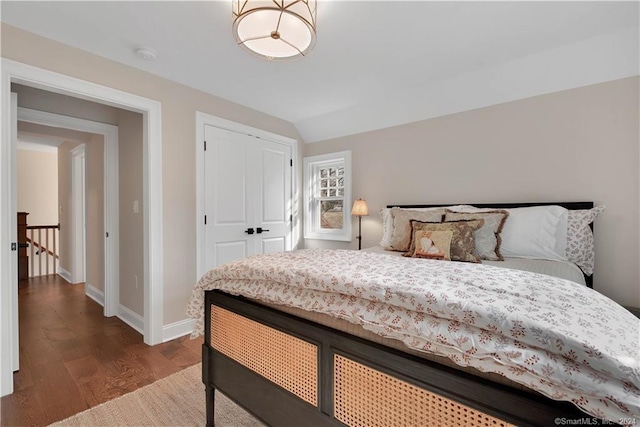 bedroom featuring lofted ceiling, a closet, and dark hardwood / wood-style flooring