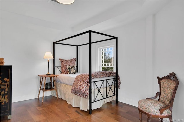 bedroom with dark wood-type flooring and beamed ceiling