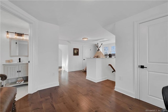 hallway featuring sink and dark wood-type flooring