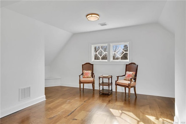 sitting room featuring lofted ceiling and dark wood-type flooring