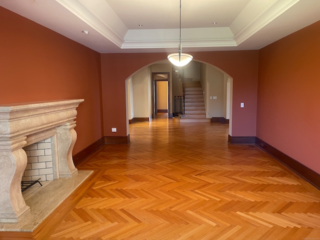 interior space with parquet floors and a tray ceiling