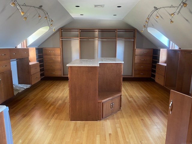 additional living space featuring vaulted ceiling and light hardwood / wood-style flooring