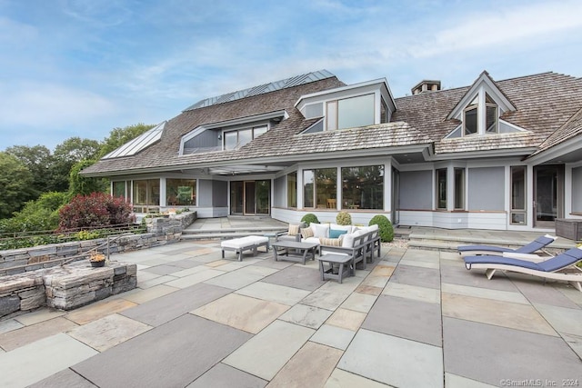 rear view of house with outdoor lounge area and a patio area