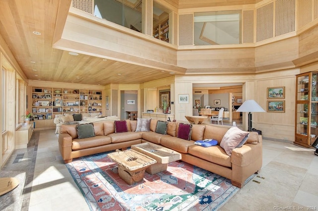 tiled living room featuring wood ceiling and a towering ceiling