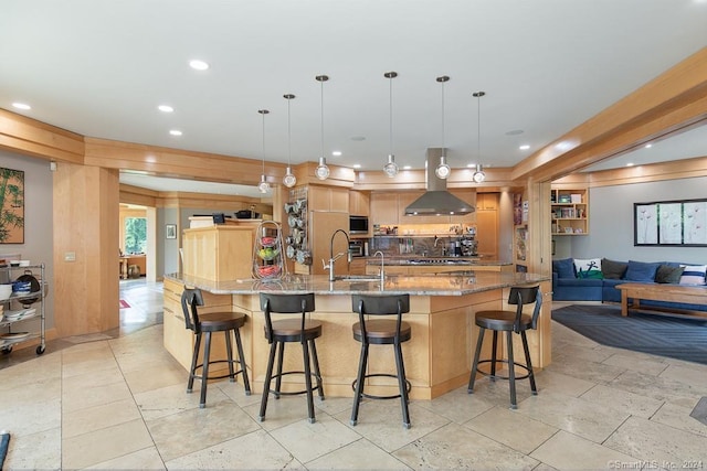 kitchen featuring a kitchen bar, hanging light fixtures, ventilation hood, and light tile flooring