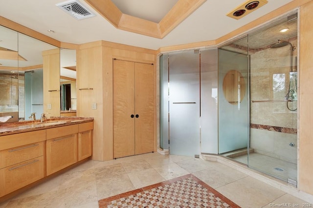 bathroom with a tray ceiling, large vanity, a shower with door, and tile flooring