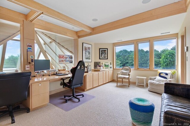 office area with built in desk, light carpet, and beamed ceiling