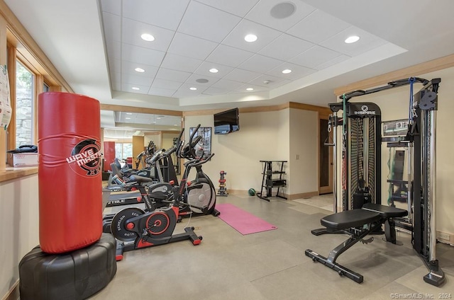 gym with a paneled ceiling and a tray ceiling