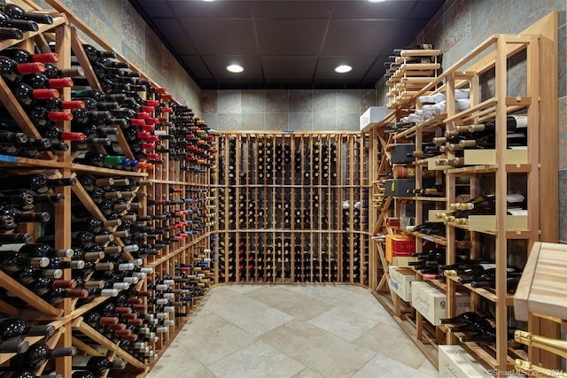 wine cellar with light tile floors and a paneled ceiling