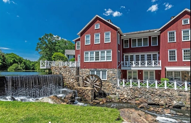 rear view of property featuring stone siding