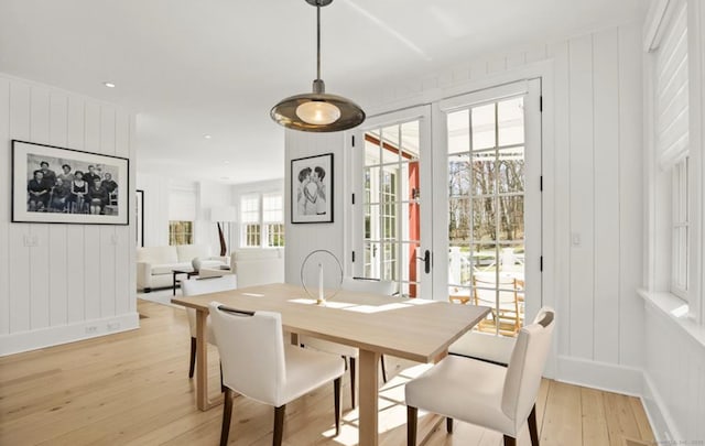 dining space with light wood-type flooring, french doors, and baseboards