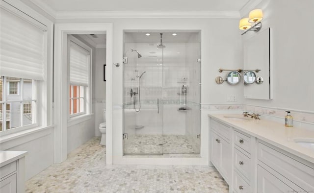 bathroom featuring crown molding, a sink, a shower stall, and double vanity