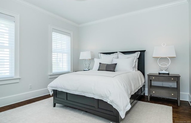 bedroom featuring baseboards, multiple windows, wood finished floors, and crown molding