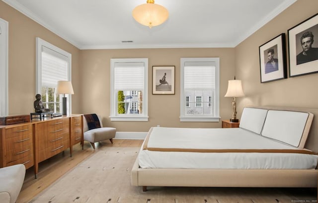 bedroom with light wood finished floors, baseboards, visible vents, and crown molding