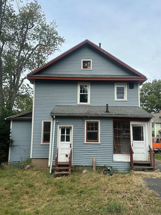 rear view of house featuring a yard