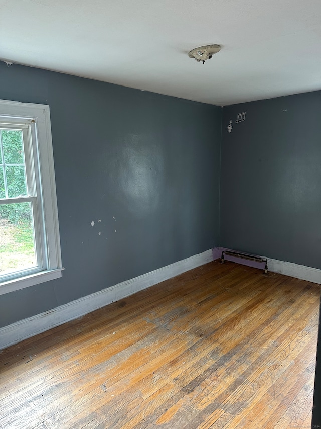 empty room with wood-type flooring and baseboard heating