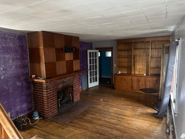 unfurnished living room with dark wood-type flooring and a fireplace