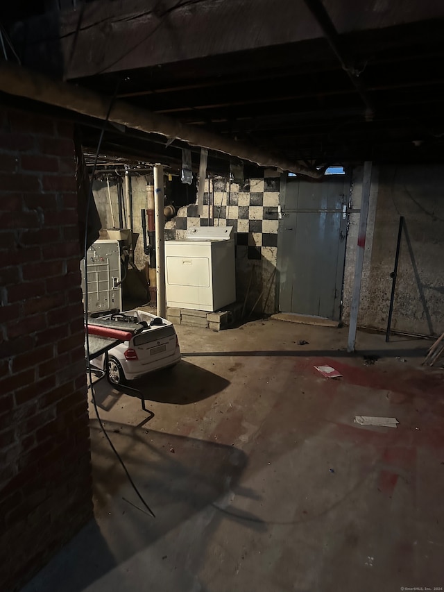 basement with brick wall and separate washer and dryer