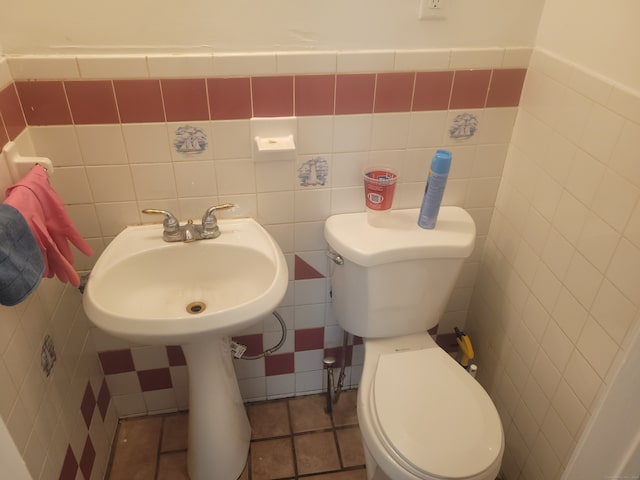 bathroom with tile flooring, backsplash, toilet, and tile walls