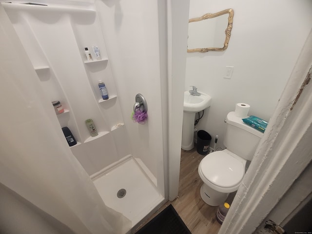 bathroom with curtained shower, wood-type flooring, and toilet