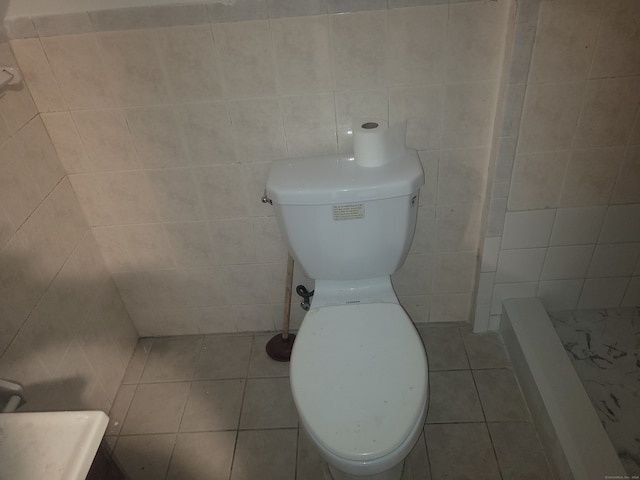 bathroom with walk in shower, tile walls, tile floors, and toilet