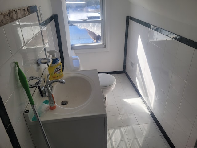 bathroom featuring tile walls, tile floors, toilet, and vanity