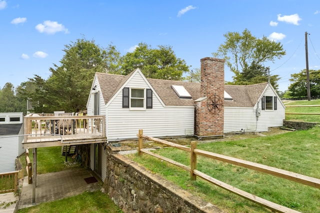 rear view of house featuring a lawn and a deck