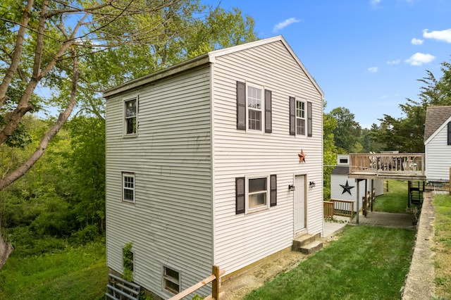 view of side of home featuring a deck and a yard