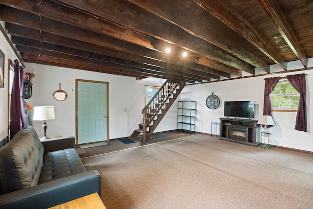 unfurnished living room featuring a fireplace, dark colored carpet, and beamed ceiling