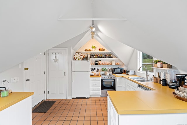 kitchen with white cabinetry, white fridge, high quality stove, sink, and light tile floors