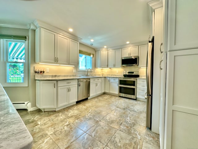 kitchen with baseboard heating, stainless steel appliances, white cabinetry, light tile patterned floors, and sink