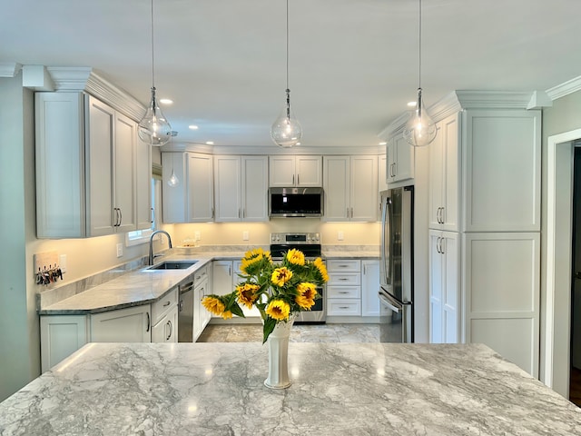 kitchen with crown molding, appliances with stainless steel finishes, hanging light fixtures, light stone countertops, and sink