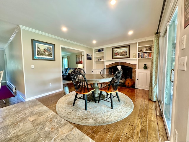 dining space with a fireplace, built in shelves, and hardwood / wood-style floors