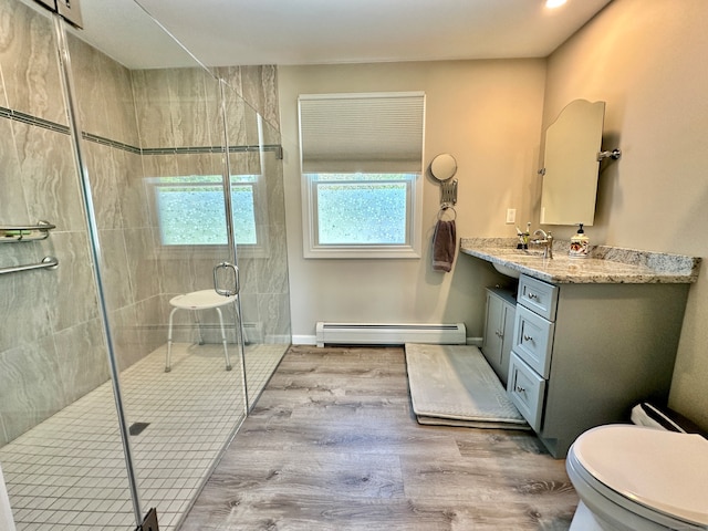 bathroom featuring a baseboard radiator, toilet, an enclosed shower, vanity, and wood-type flooring