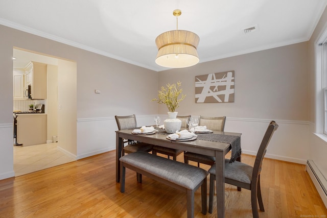 dining space with visible vents, crown molding, baseboards, baseboard heating, and light wood-style floors