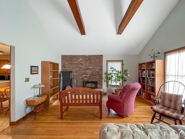 living room with beam ceiling, light hardwood / wood-style floors, and high vaulted ceiling