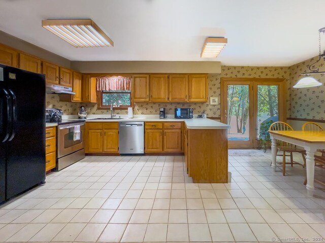 kitchen featuring sink, light tile patterned flooring, hanging light fixtures, and appliances with stainless steel finishes